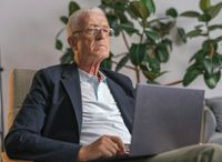 Senior mit Laptop auf dem Schoß – Computerschulung für Senioren bei Schüller Computer & Internet